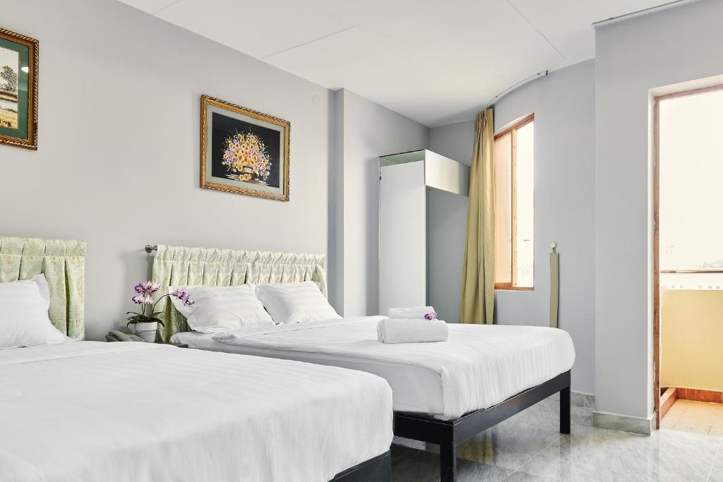 2 camas en una habitación con paredes blancas en Song Anh 1 Hotel, en Ho Chi Minh