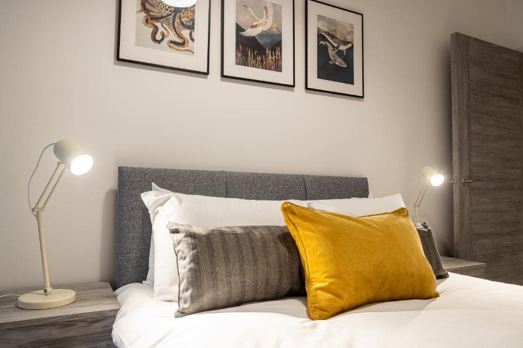 ein Schlafzimmer mit einem Bett und einem gelben Kissen in der Unterkunft Comfortable City Centre 2 Bedroom Apartment in Peterborough