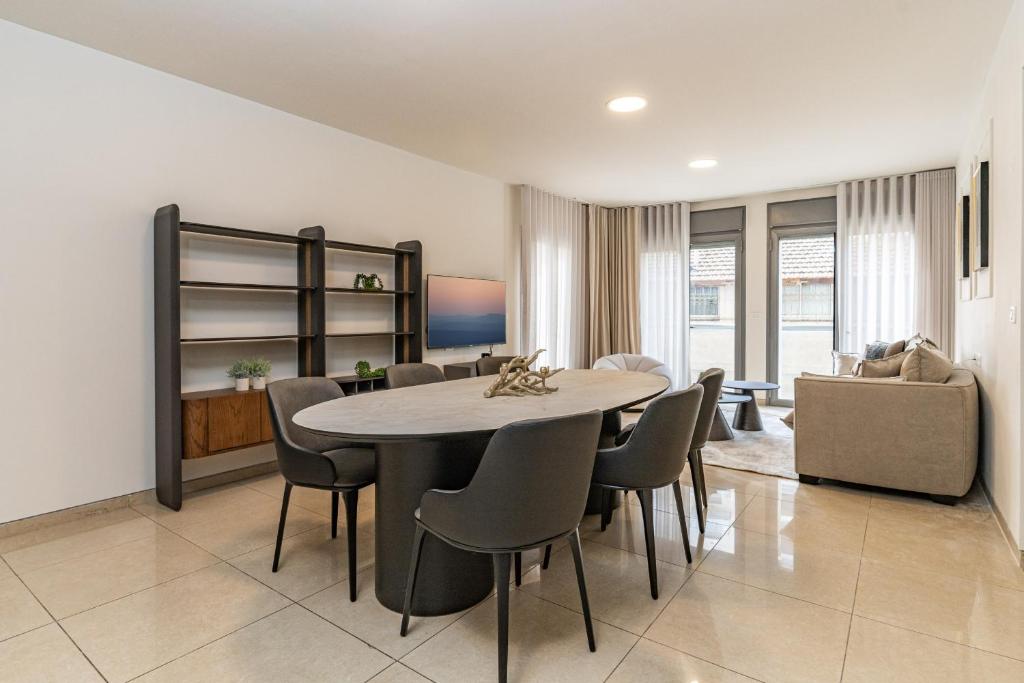 ein Wohnzimmer mit einem Esstisch und Stühlen in der Unterkunft Luxury and Large 2 Bedroom - Rav Kuk Residence in Jerusalem