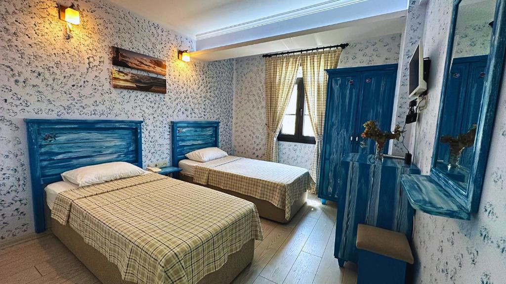 チェシメにあるMai̇ Hotelの青い壁のドミトリールーム ベッド2台