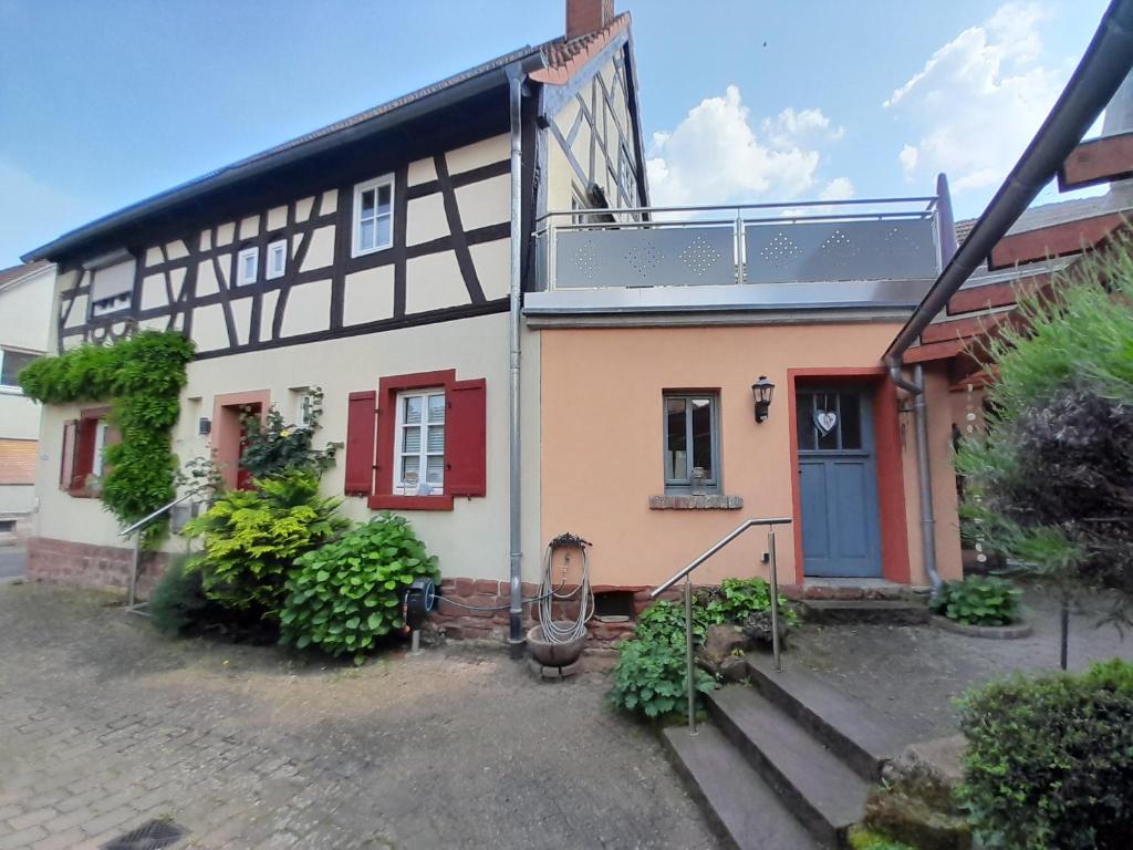 uma casa com uma porta azul e janelas vermelhas em Ferienwohnung Camino em Jockgrim