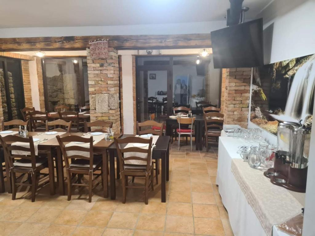 a restaurant with tables and chairs in a room at Guest house Slatki Snovi in Knin