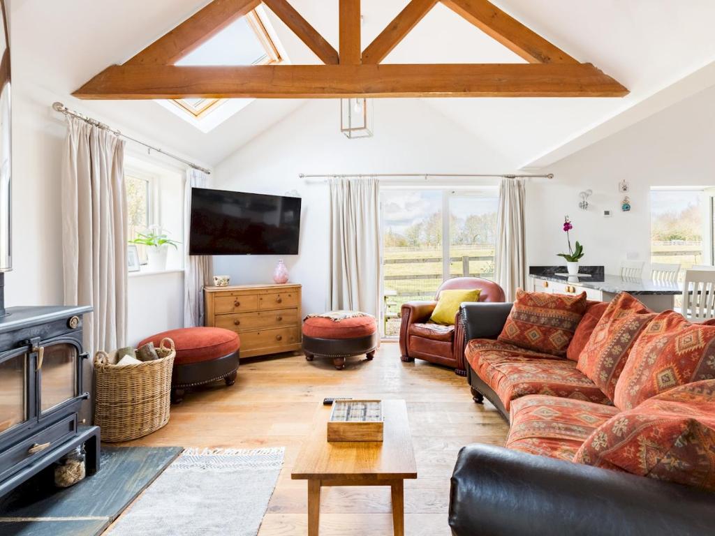 a living room with a couch and a tv at Pass the Keys Quality Rural 2 Bed Cottage Retreat in Warwick