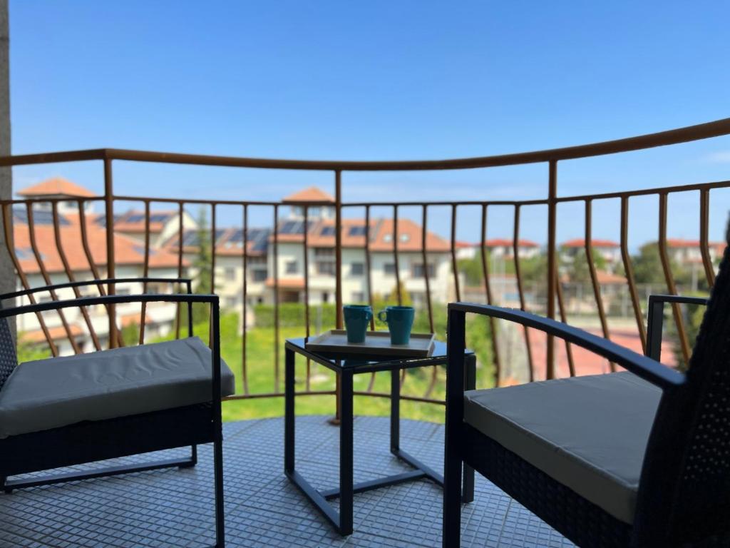 two chairs and a table on a balcony with a view at Skyline apartment in Sinemorets