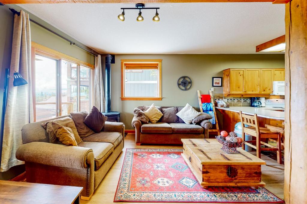 a living room with two couches and a table at Snow Leopard's Retreat in Big White