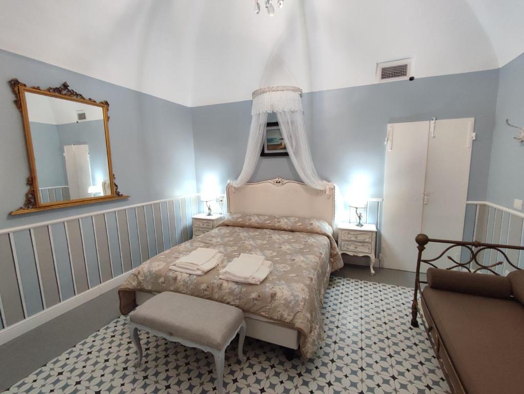 ein Schlafzimmer mit einem Bett mit einem Spiegel und einem Stuhl in der Unterkunft Bouquet di Note in Cervo