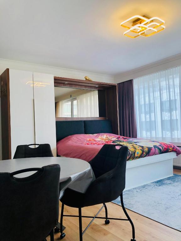 una camera con letto, tavolo e sedie di DeLuxe Studio Sun a Ostenda