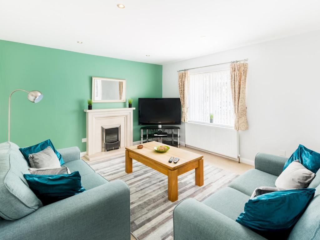 Sala de estar con 2 sofás azules y mesa de centro en Pass the Keys Self Contained 2 Bed with Parking Leamington Spa en Leamington Spa