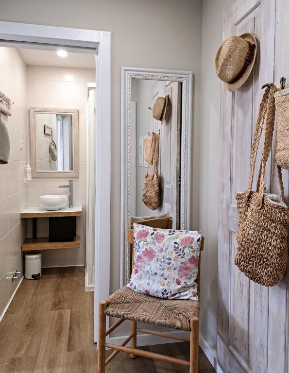 a bathroom with a chair with a pillow and a mirror at Casa Recanto do Teatro in Lamego