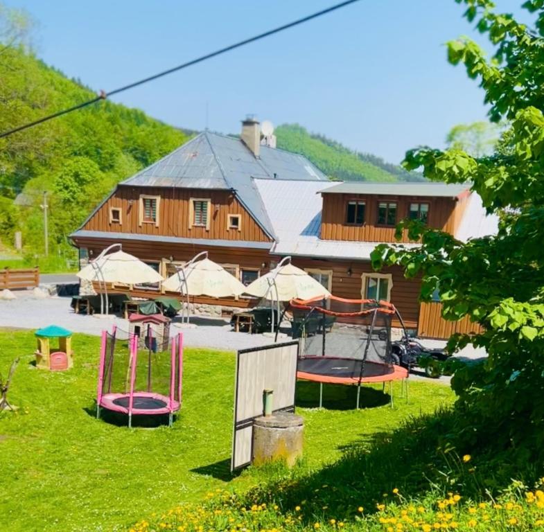 a building with a bunch of play equipment in the grass at pension U Jiřího in Ludvíkov