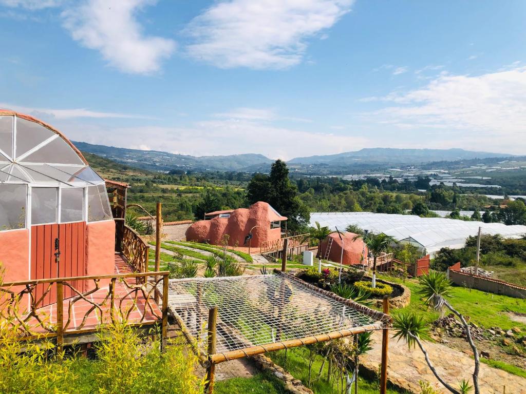 uma vista para uma quinta com uma piscina num campo em Glamping Sierra de Luna em Villa de Leyva