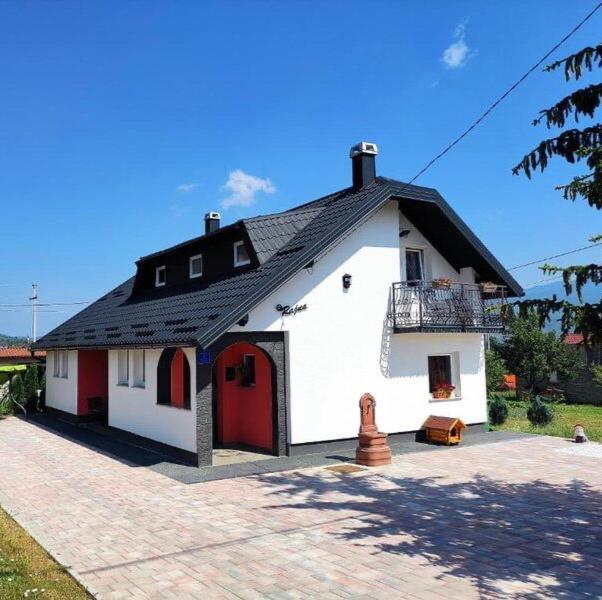 a small white house with a black roof at Relax Home ®Rajna® in Korenica