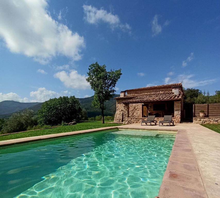 een zwembad voor een stenen huis bij Can Nofre - Masia familiar en zona tranquila in Amer