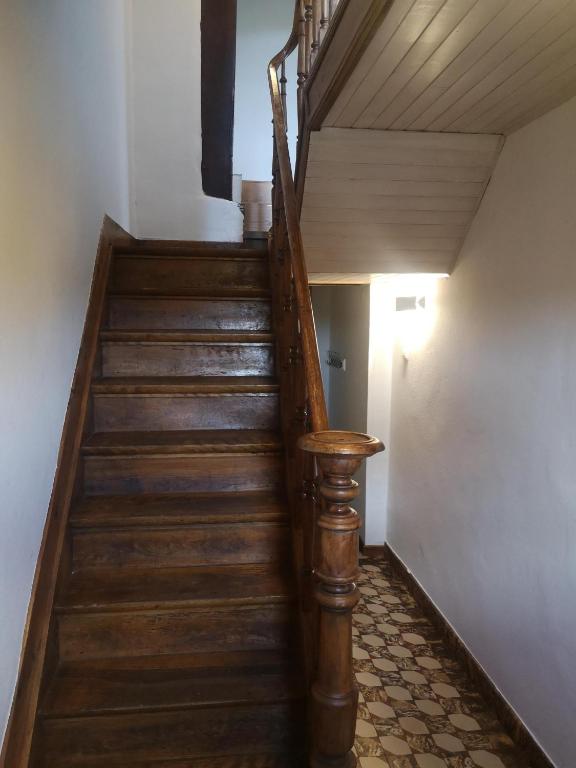 a staircase in a house with a wooden stair case at Gîte Les trois charmes in Gouvy