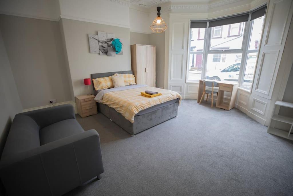 a bedroom with a bed and a chair and a window at The Royalty in Sunderland