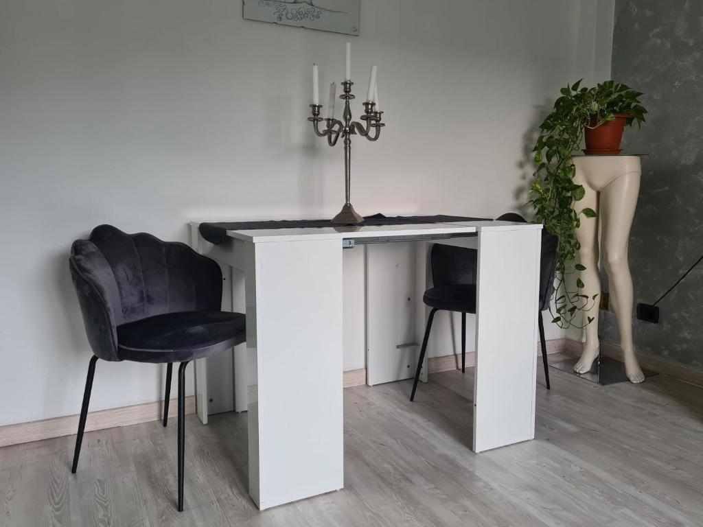 una mesa blanca con 2 sillas y una planta en Casa Vacanza Luce en Como
