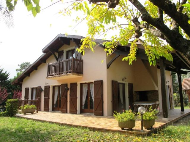 une maison avec un porche et un balcon dans l'établissement La rose du pley - Seignosse spacieuse villa dans quartier calme et résidentiel, à Seignosse