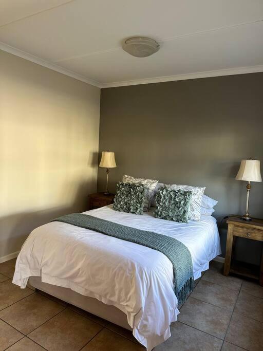 a bedroom with a large white bed with pillows at El Dorado 78 in Oudtshoorn