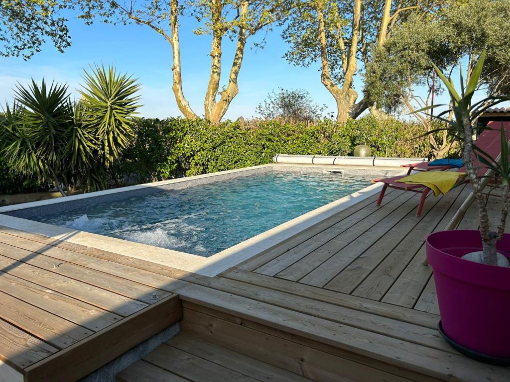 una piscina con terraza de madera junto al avisor en Villa au calme avec Piscine Jacuzzi, en Ventenac en Minervois