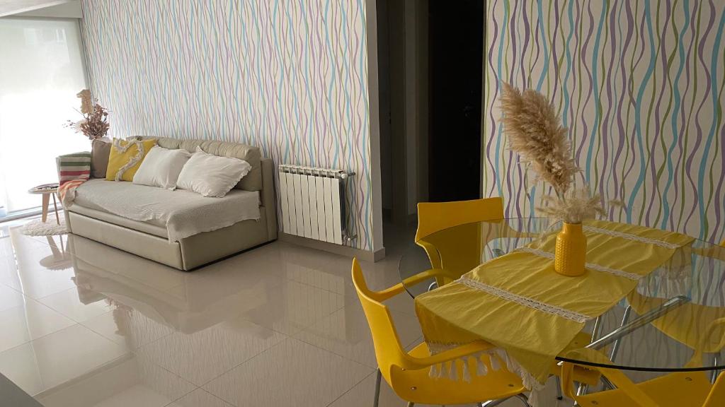 sala de estar con mesa amarilla y sofá en Departamento TIERRA VI en Salta