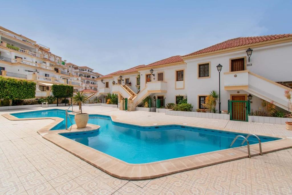 una piscina nel mezzo di un cortile con edifici di Terrace View Studio ad Adeje