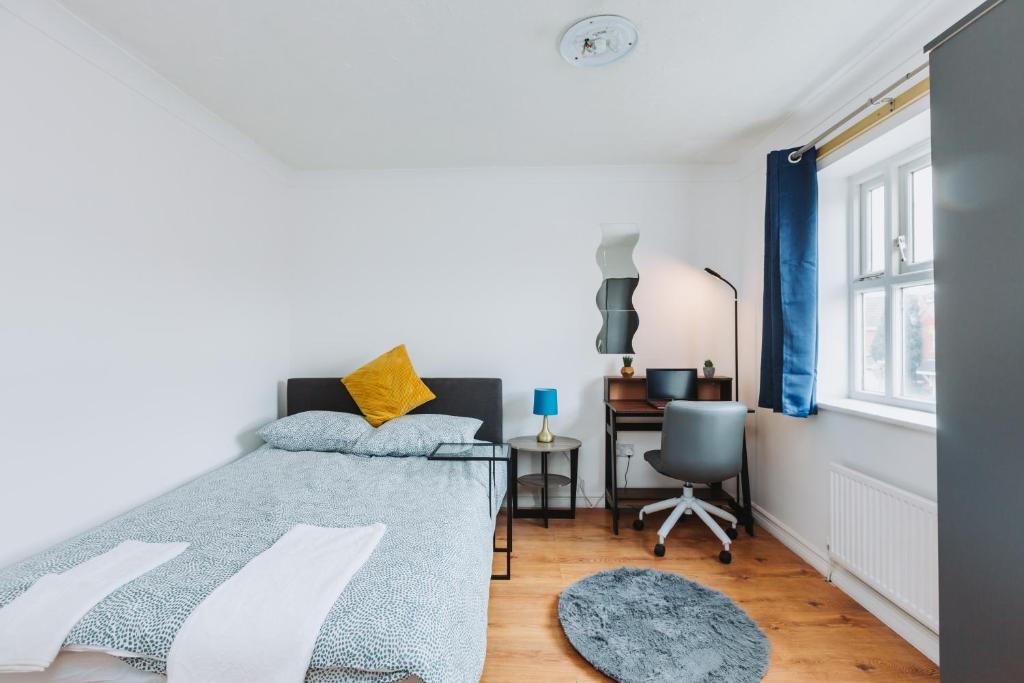 a bedroom with a bed and a desk at The Dahlia Rooms - free parking & wifi in Barking