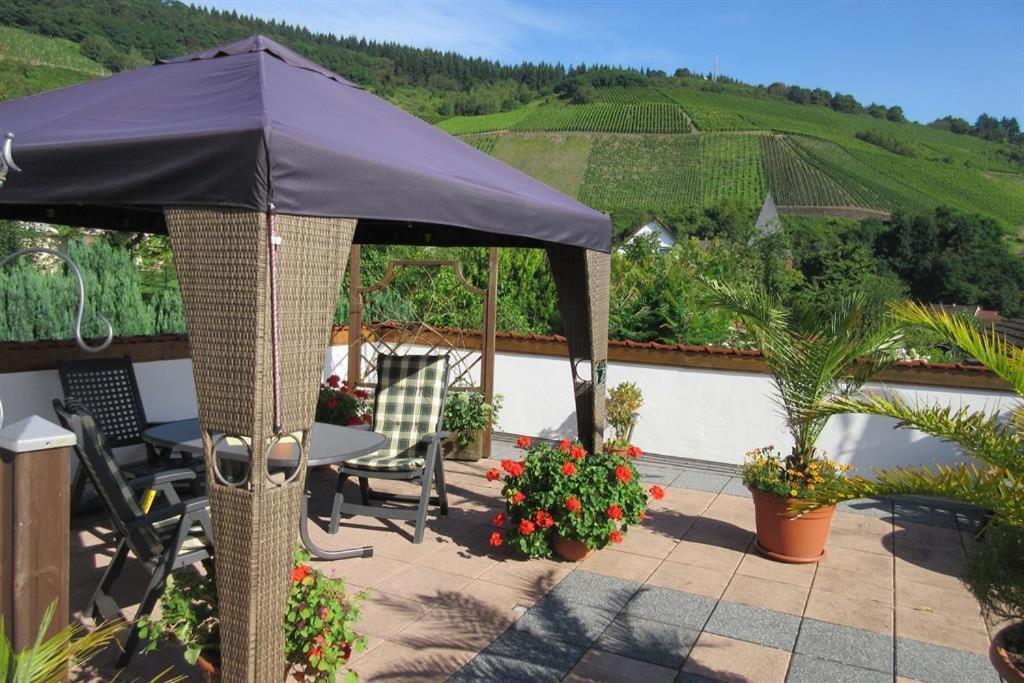a patio with an umbrella and a table and chairs at Ferienwohnung Wilhelmi in Saarburg