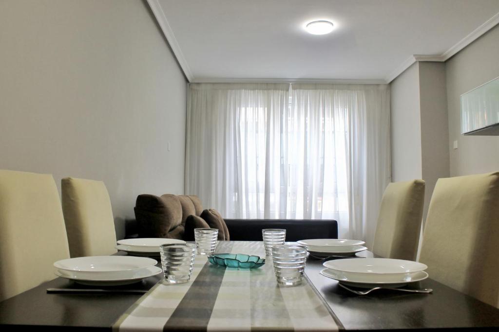 a dining room table with plates and glasses on it at Abad Paterno - 3008 in Santoña