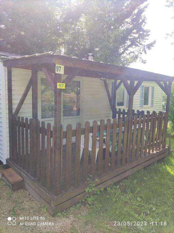 een houten hek voor een huis bij Camping les tilleuls du caminel Mobile home 97 in Sarlat-la-Canéda