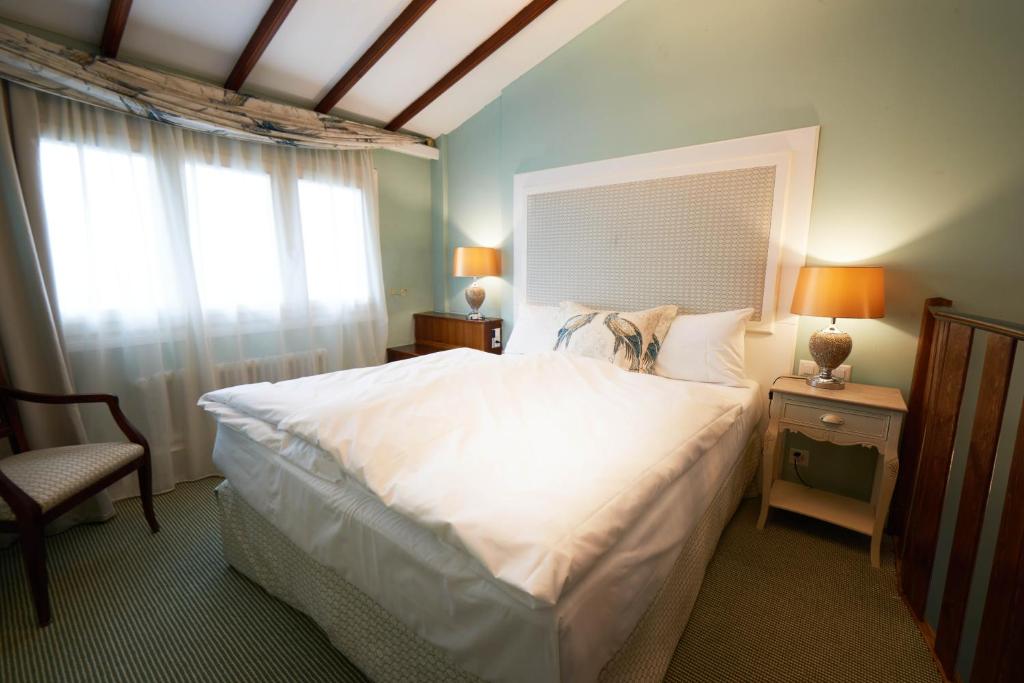 a bedroom with a large white bed with a window at Château Gütsch in Luzern