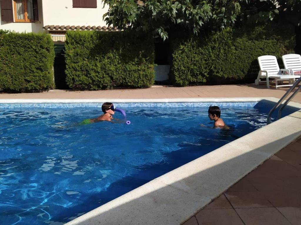 2 personnes jouant au frisbee dans une piscine dans l'établissement Estel, à L'Escala