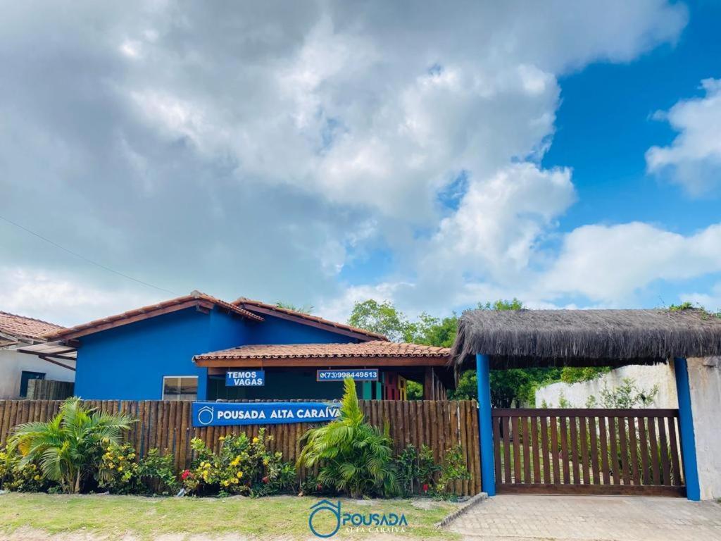 um edifício azul com uma cerca em frente em Pousada Alta Caraíva em Caraíva