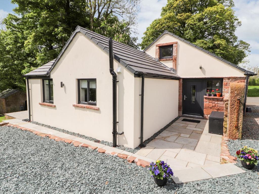 a white cottage with a garage at Lands Brow Lodge in Red Dial