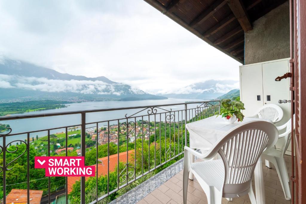 een balkon met een tafel en stoelen en uitzicht op het water bij Un Balcone sul Lago by Wonderful Italy in Montemezzo