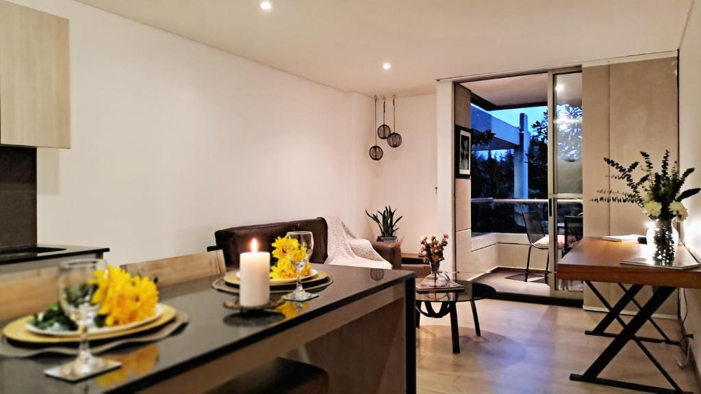 cocina y sala de estar con mesa y vela en Apartment in countryside with hotel services, en Rionegro