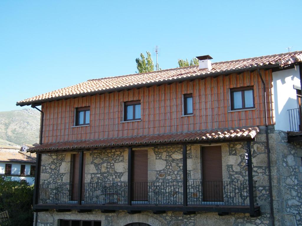 una casa con un balcón en el lateral. en Casa Rural Puerta del Sol de 3 habitaciones, en Candelario