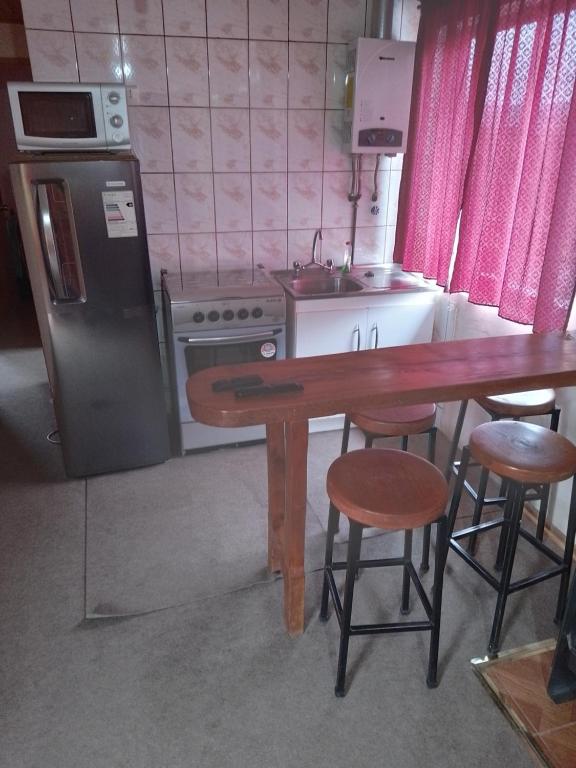 a kitchen with a wooden table and a refrigerator at Cabañas Aron in San Fabián de Alico