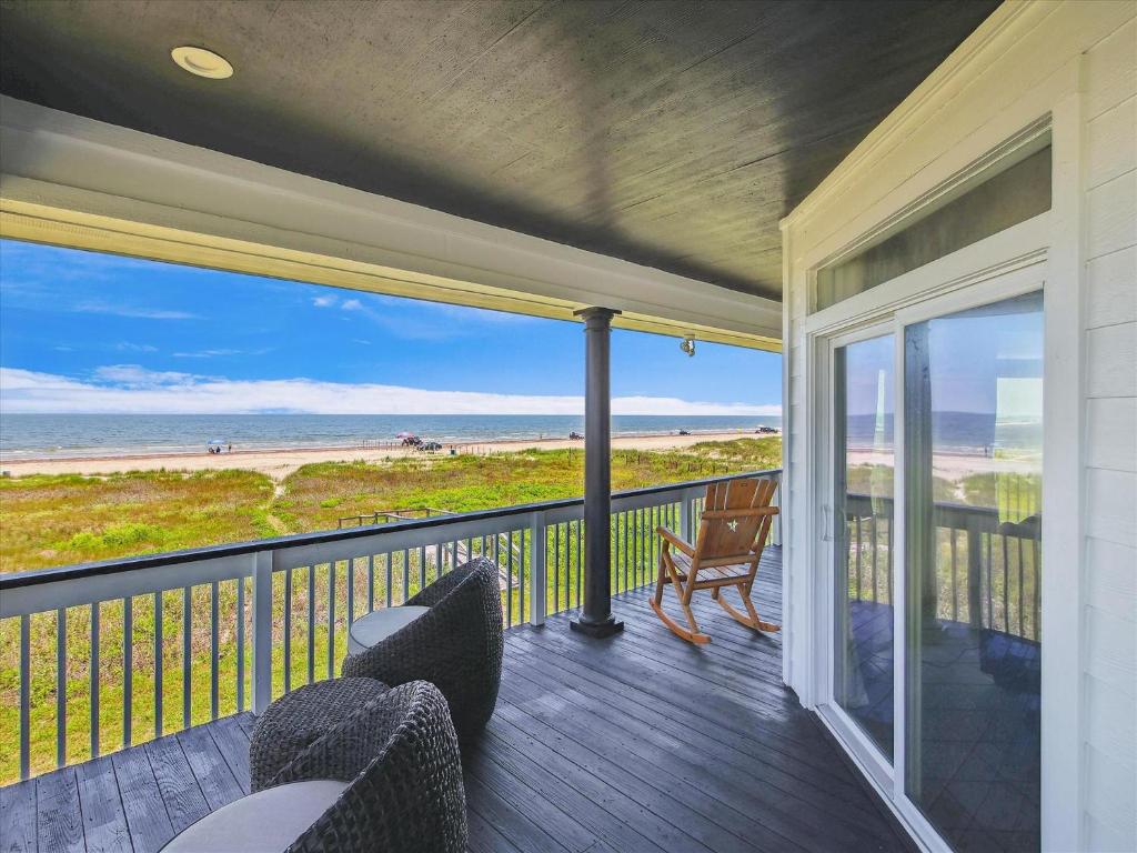a porch with chairs and a view of the beach at Oceanside Paradise in Galveston