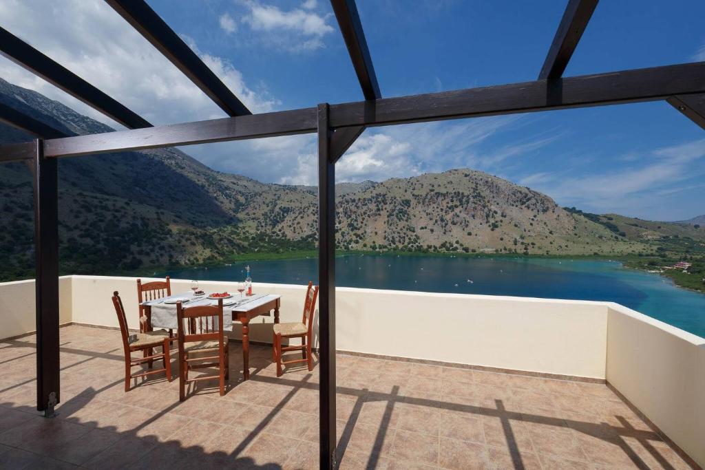 a view from the balcony of a house with a table and chairs at Lakescape Villa In Kournas - Amazing View in Kávallos