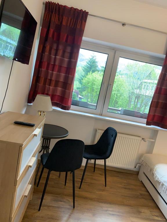 a room with two chairs and a desk and two windows at Pokoje Sunshine World Suites in Zakopane