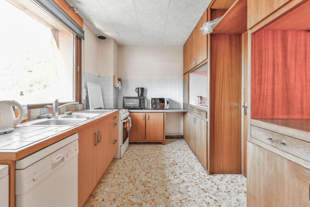 a kitchen with wooden cabinets and a sink and a window at Appartement de 2 chambres avec balcon amenage et wifi a Courchevel a 6 km des pistes in La Perrière