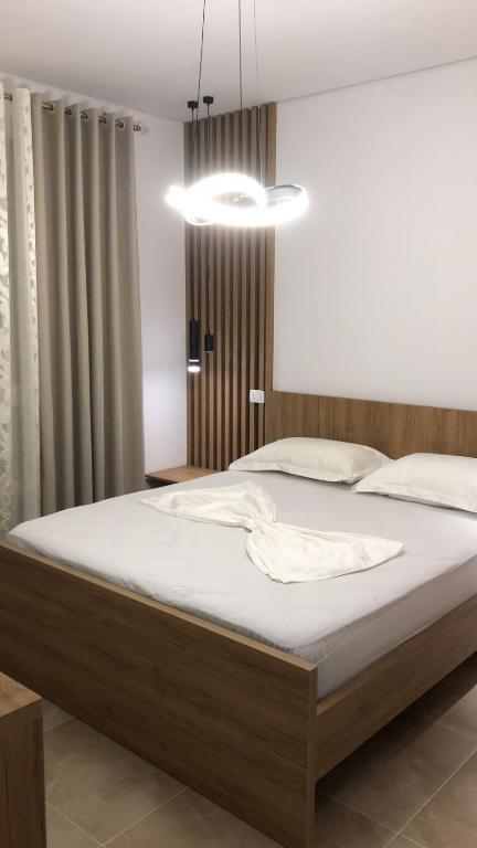 sypialnia z dużym łóżkiem z białą pościelą w obiekcie Illyrian Elite Gjiri i Lalezit w Durrës