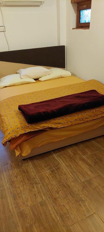 a bed sitting on a wooden floor in a bedroom at Vikendica Raj u prirodi in Prijedor