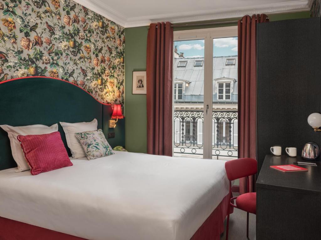 a bedroom with a large bed and a window at Hôtel Brittany in Paris