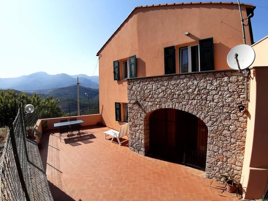 a stone building with a balcony with a table at Casa Vacanze IL Primo Sole in Finale Ligure