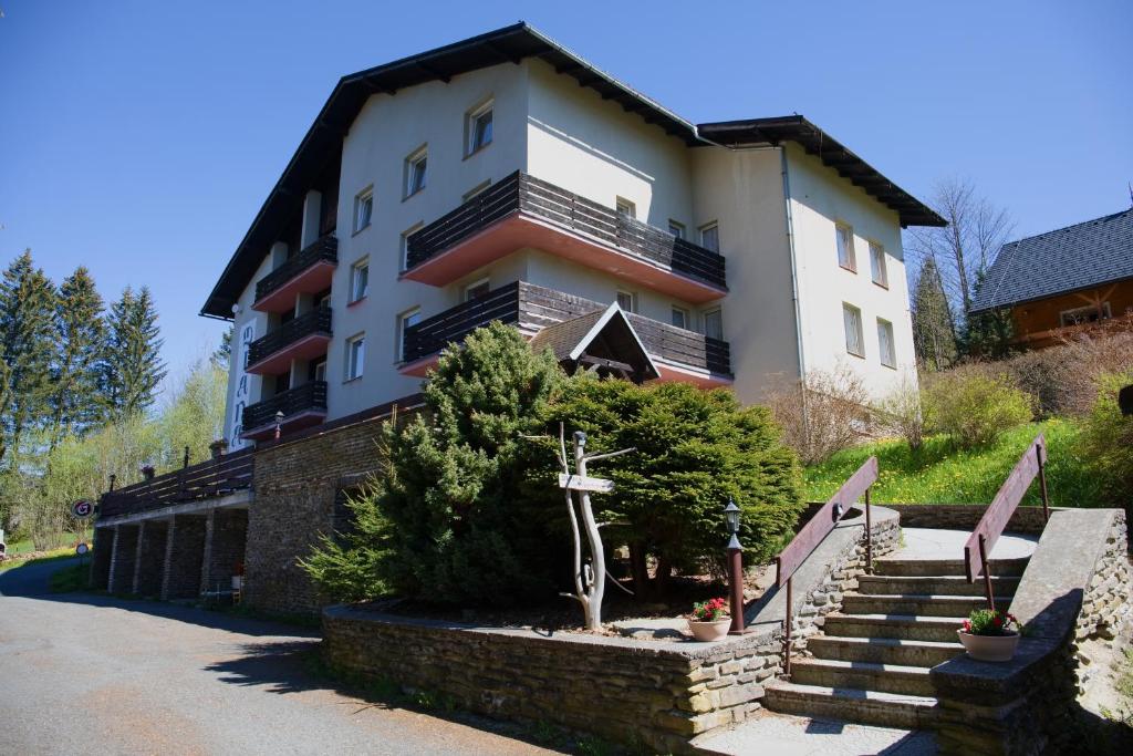 a building with a cross in front of it at Penzion Diana in Železná Ruda