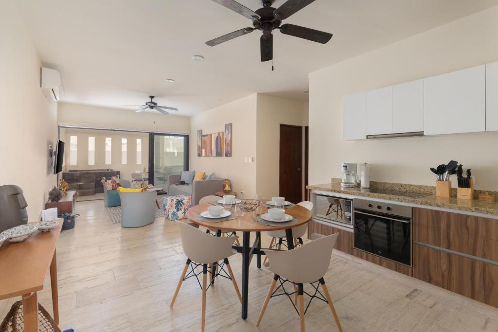 eine Küche und ein Wohnzimmer mit einem Tisch und Stühlen in der Unterkunft Stylish Condo - Private Plunge Pool - 300Mbps - Rooftop in Playa del Carmen