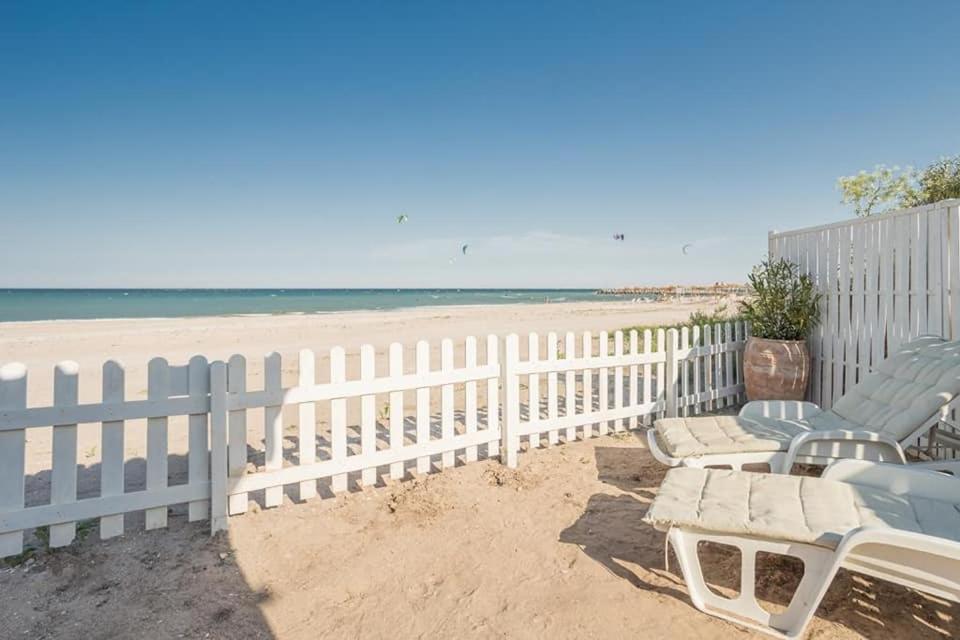 una valla blanca y sillas en la playa en Casa Blanca Olimp, en Olimp