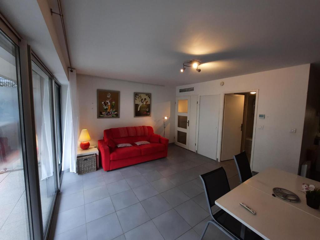 a living room with a red couch and a table at Appartement Bayonne, 1 pièce, 2 personnes - FR-1-239-906 in Bayonne