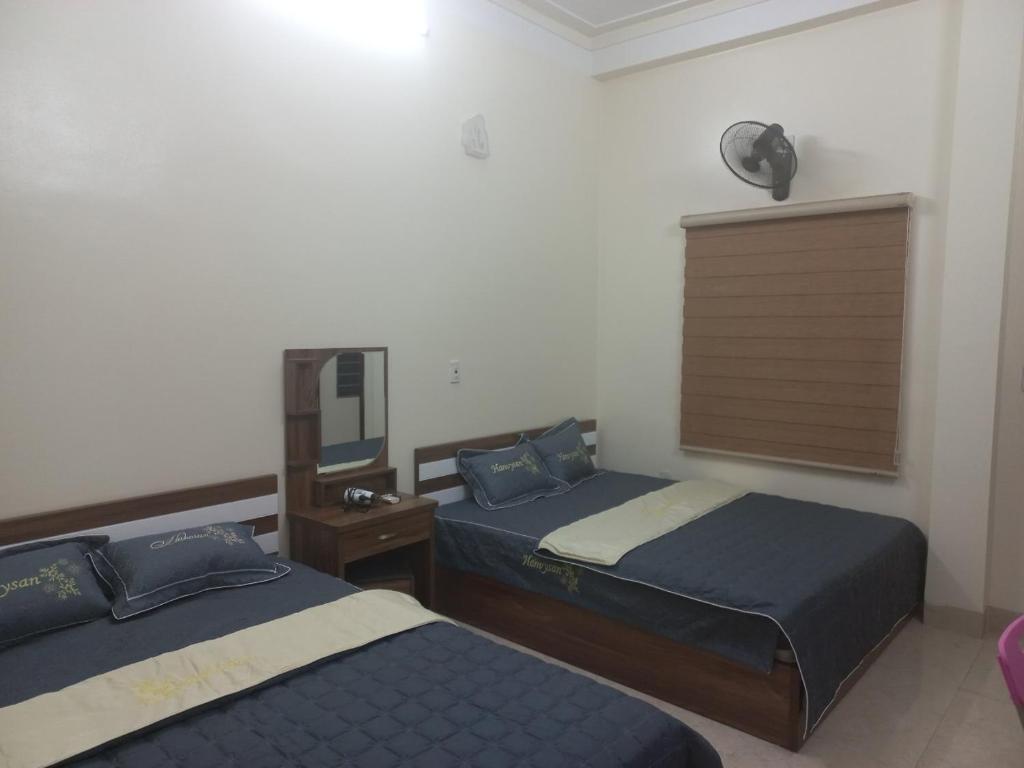 Pokój hotelowy z 2 łóżkami i lustrem w obiekcie Homestay Quyết Thương w mieście Cao Bằng